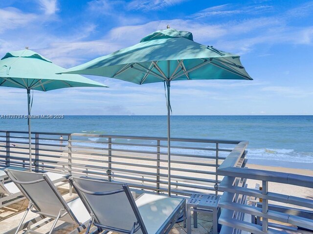 exterior space featuring a water view, a balcony, and a view of the beach