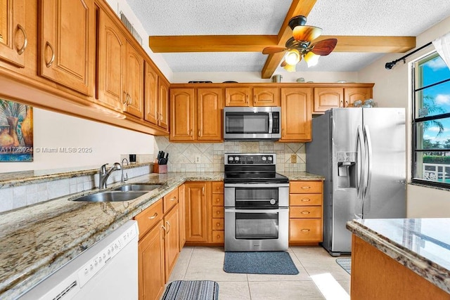 kitchen featuring sink, beam ceiling, stainless steel appliances, light tile patterned flooring, and decorative backsplash