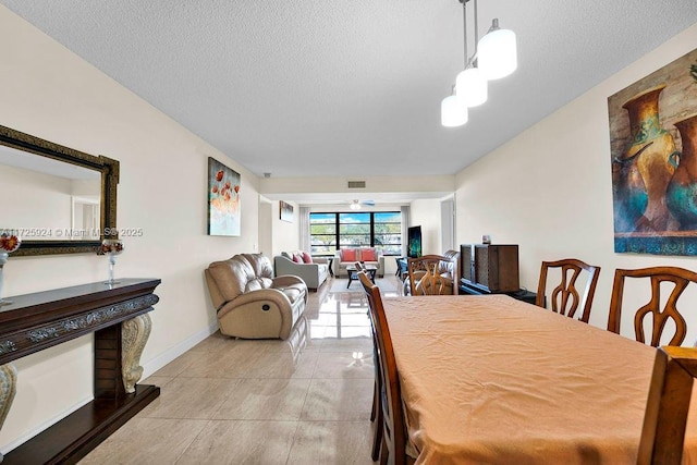 dining area featuring a textured ceiling and light tile patterned floors