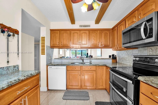 kitchen with sink, stainless steel appliances, light stone counters, light tile patterned flooring, and beamed ceiling