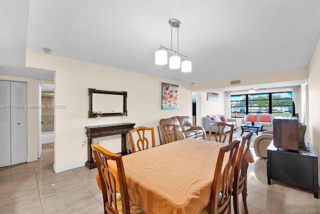 tiled dining area featuring a textured ceiling