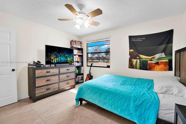 tiled bedroom with a textured ceiling and ceiling fan