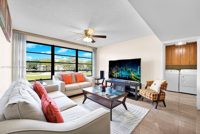 living room featuring ceiling fan, washing machine and clothes dryer, a textured ceiling, and light tile patterned floors