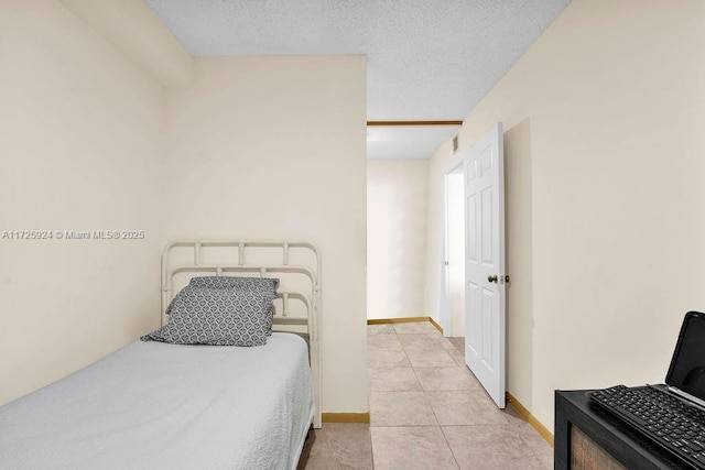 tiled bedroom featuring a textured ceiling