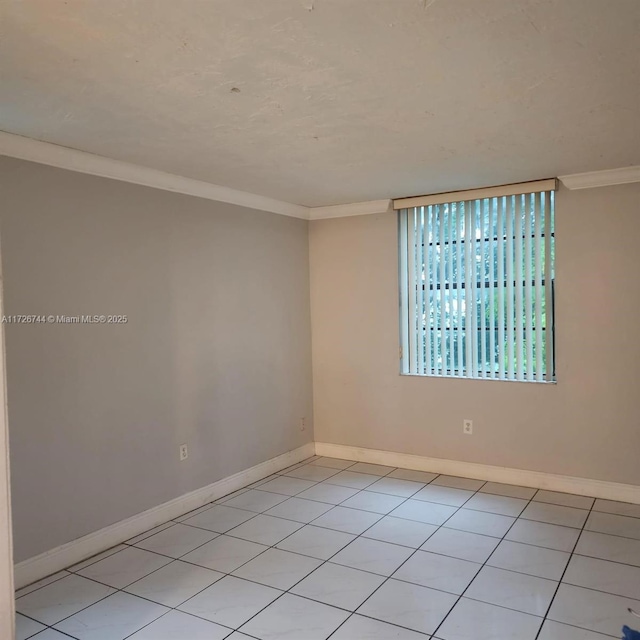 spare room with light tile patterned floors and ornamental molding