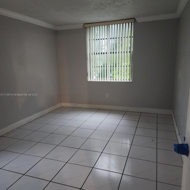 tiled empty room with a textured ceiling and ornamental molding