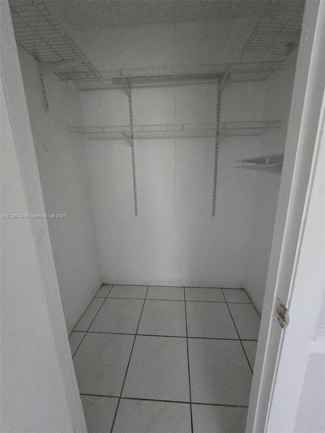 walk in closet with tile patterned floors