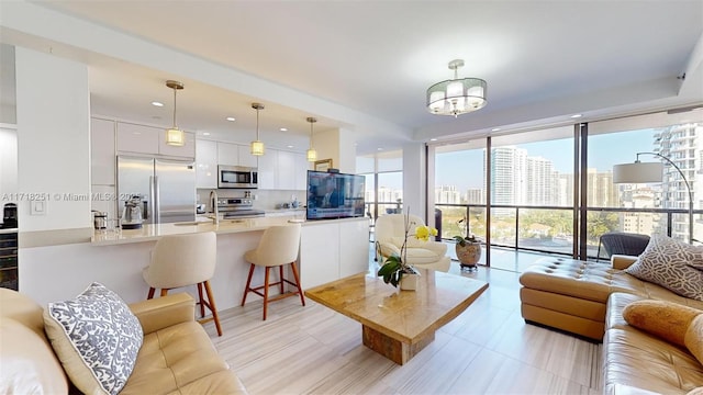 living room with sink, a wall of windows, and a chandelier