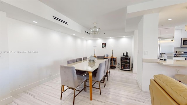 dining area featuring an inviting chandelier and light tile patterned flooring