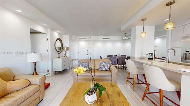 living room featuring sink and light hardwood / wood-style flooring