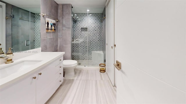 bathroom with toilet, a shower with door, and vanity