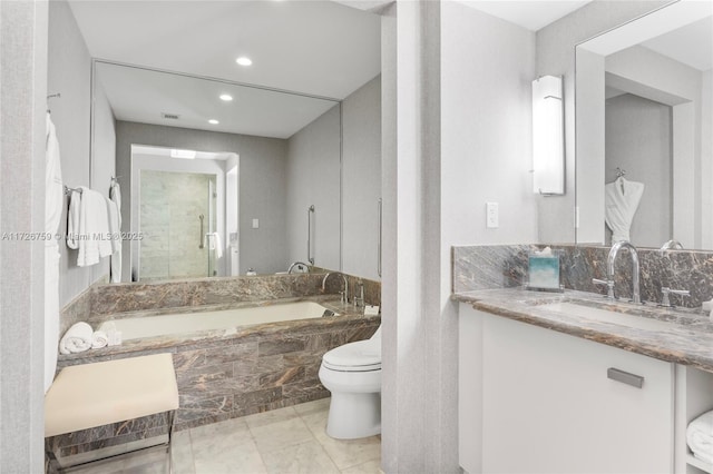 bathroom featuring toilet, vanity, and a relaxing tiled tub