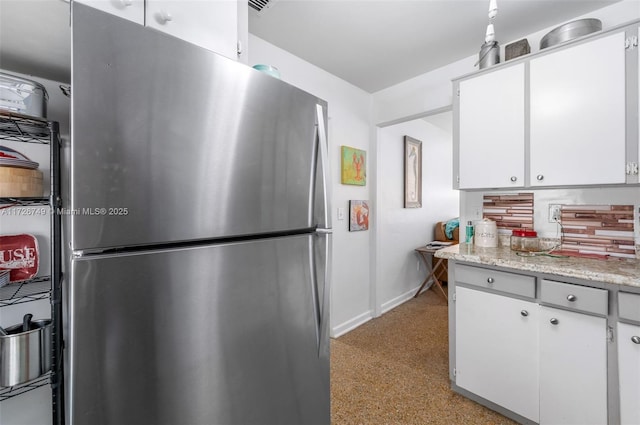 kitchen featuring white cabinetry and stainless steel refrigerator