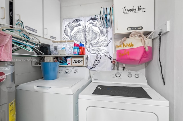 clothes washing area featuring washer and dryer and cabinets