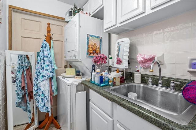 clothes washing area with sink, stacked washer / dryer, and tile walls