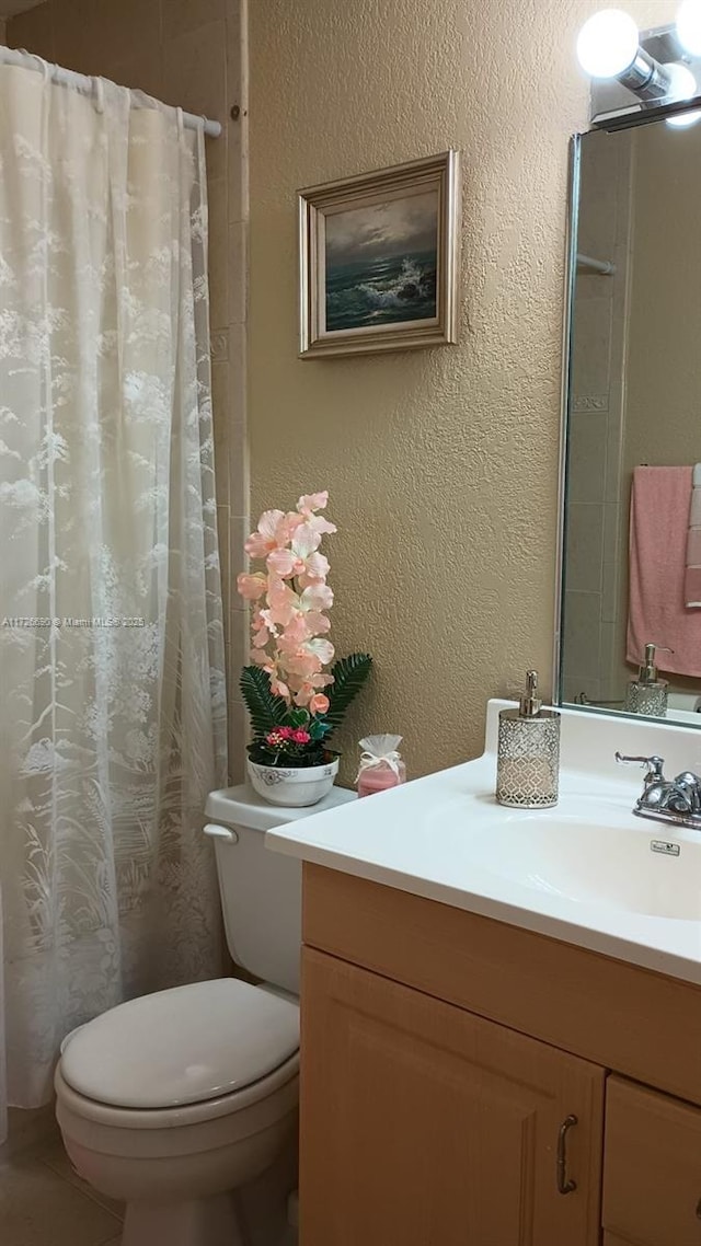 bathroom featuring a shower with curtain, vanity, and toilet