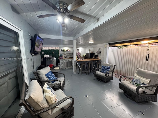 view of patio featuring an outdoor kitchen, ceiling fan, and a bar