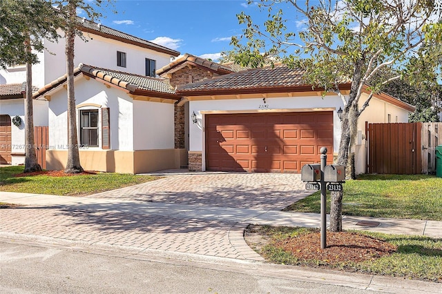 mediterranean / spanish-style home featuring a garage and a front lawn