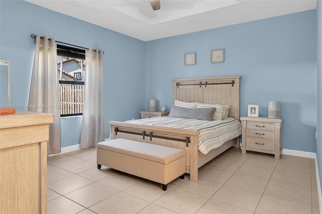 tiled bedroom featuring ceiling fan and a raised ceiling