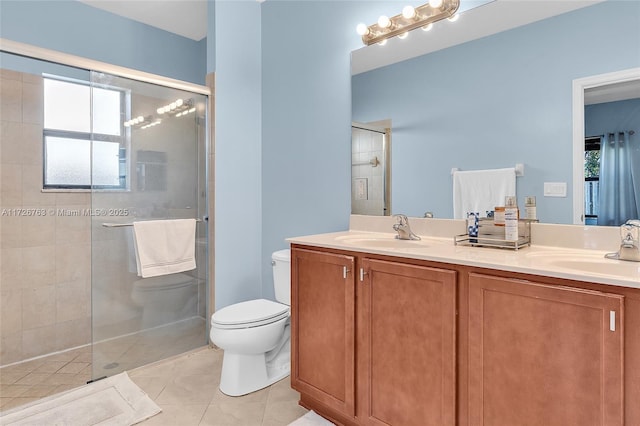 bathroom featuring toilet, tile patterned flooring, a shower with door, and vanity