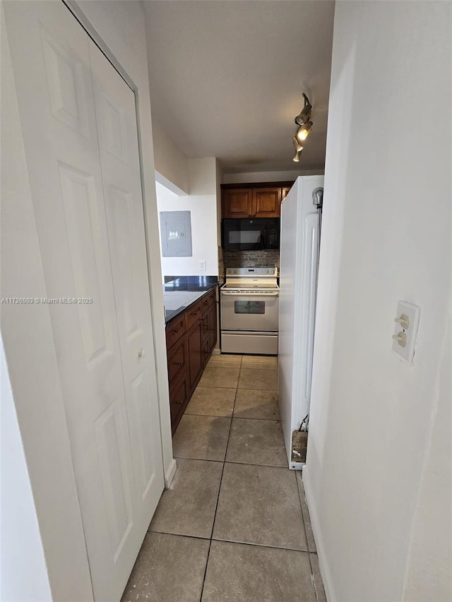 kitchen with light tile patterned flooring, white appliances, and electric panel