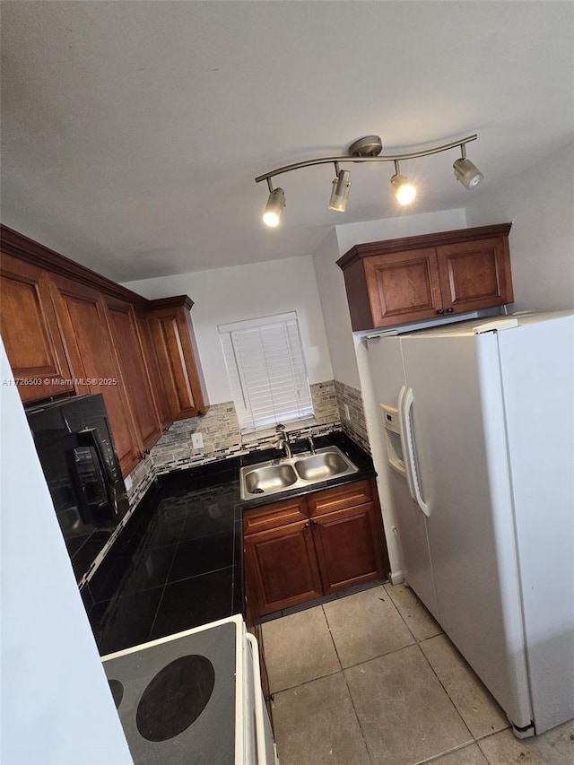 kitchen featuring tasteful backsplash, light tile patterned flooring, white fridge with ice dispenser, range, and sink