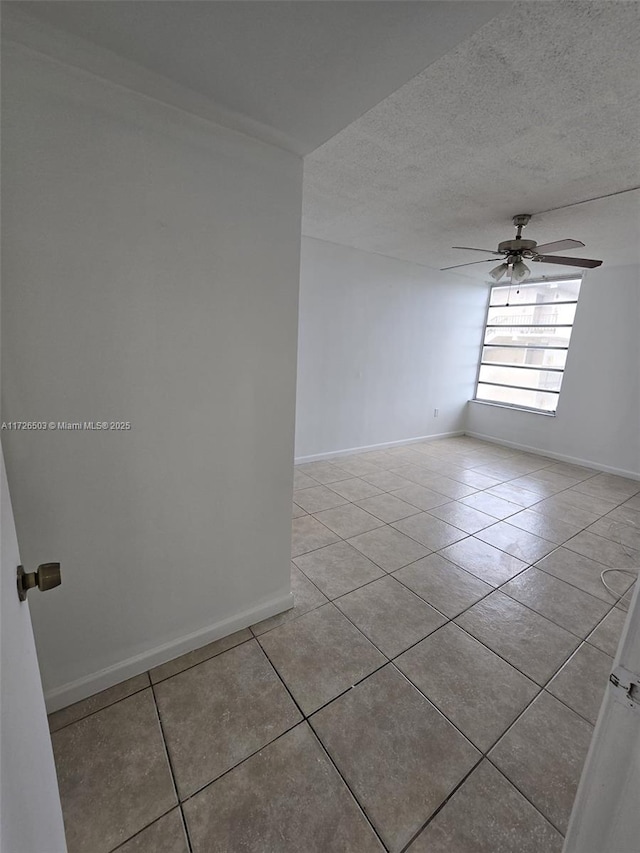 unfurnished room with ceiling fan, a textured ceiling, and light tile patterned floors