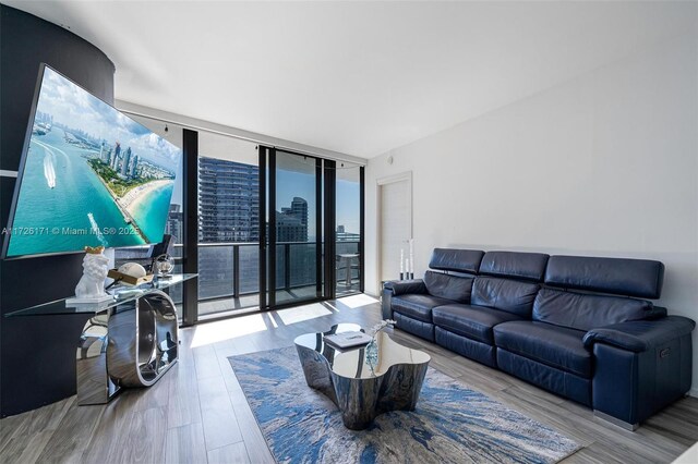 living room featuring floor to ceiling windows and light hardwood / wood-style floors