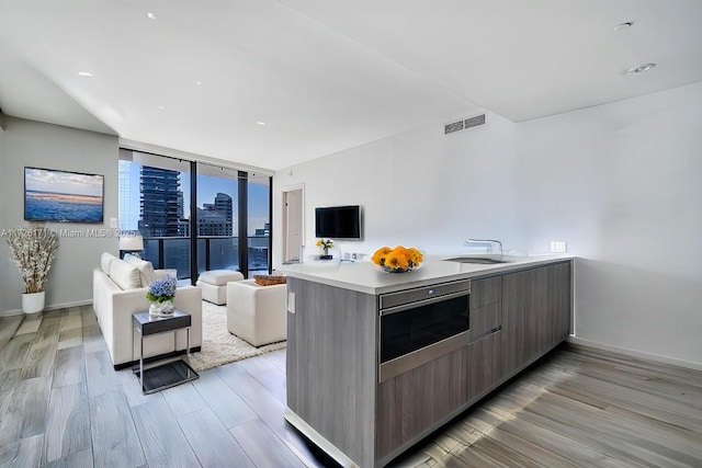 kitchen featuring a sink, modern cabinets, light wood-style floors, visible vents, and light countertops