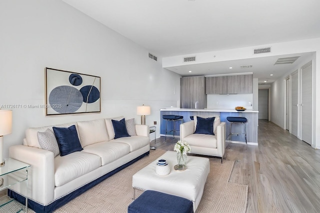 living room with visible vents and light wood-style flooring