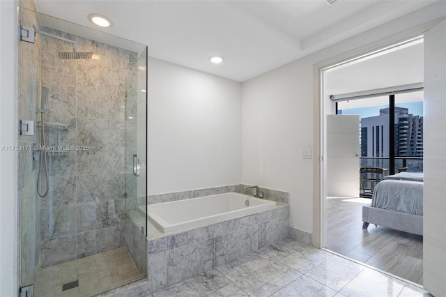 ensuite bathroom with ensuite bathroom, recessed lighting, a bath, and a stall shower