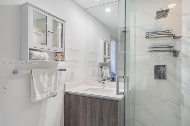 bathroom with recessed lighting, a shower stall, and vanity