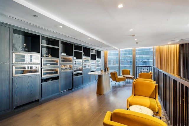interior space with floor to ceiling windows, recessed lighting, wood finished floors, and a kitchen island
