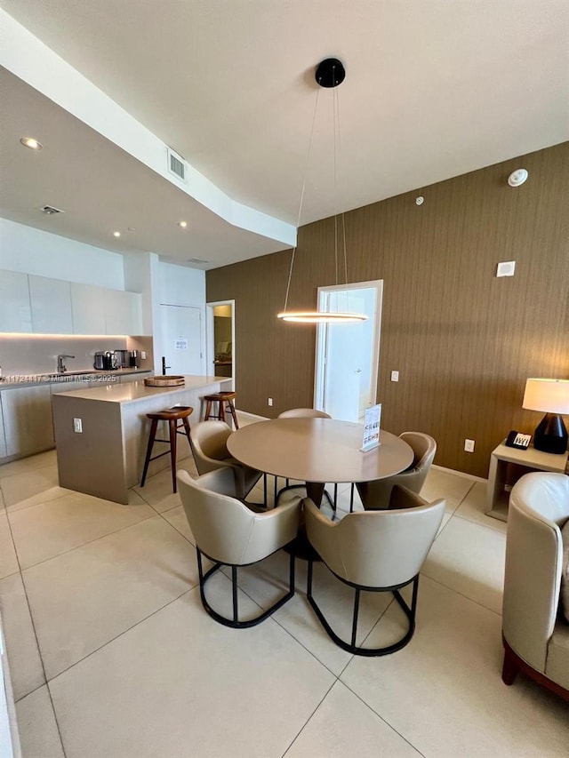 tiled dining space with sink and wooden walls