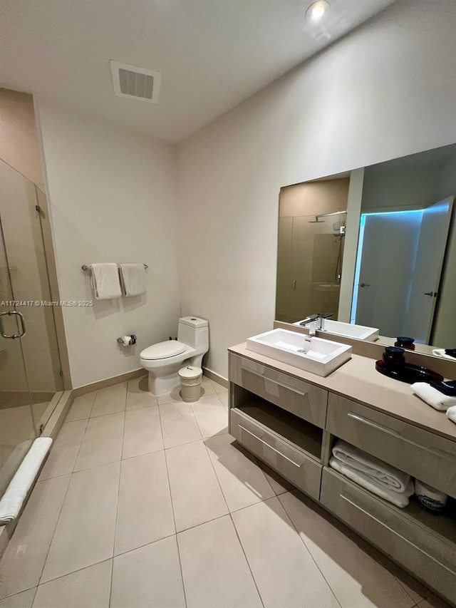 bathroom featuring toilet, vanity, tile patterned floors, and walk in shower