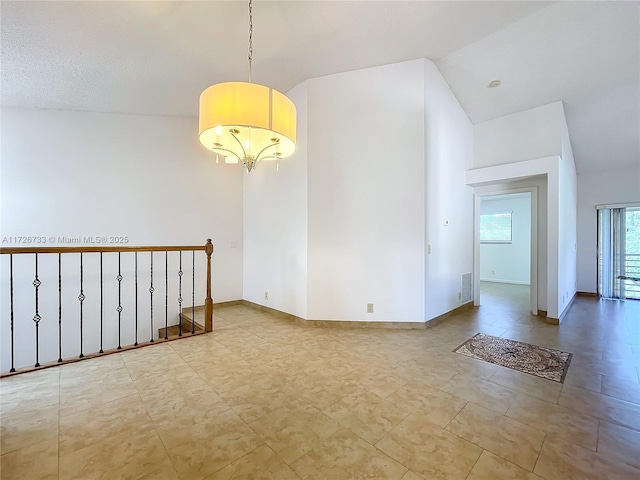 unfurnished room with vaulted ceiling and a notable chandelier