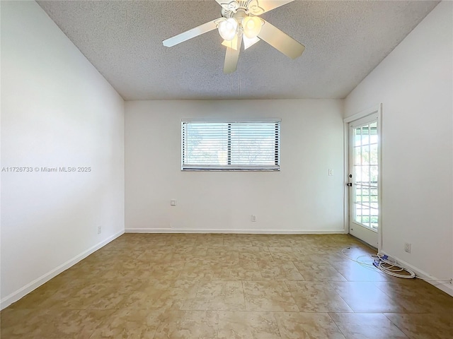 tiled empty room featuring ceiling fan and a textured ceiling