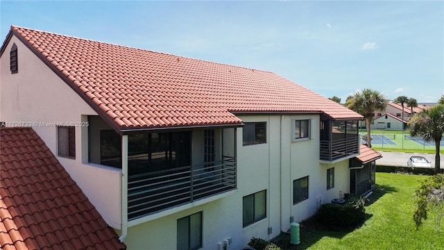 rear view of property with central AC, a lawn, and a sunroom