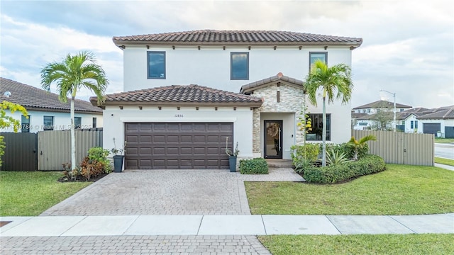 mediterranean / spanish home with a garage and a front lawn