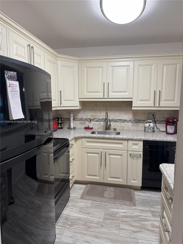 kitchen featuring light stone countertops, sink, backsplash, and black appliances