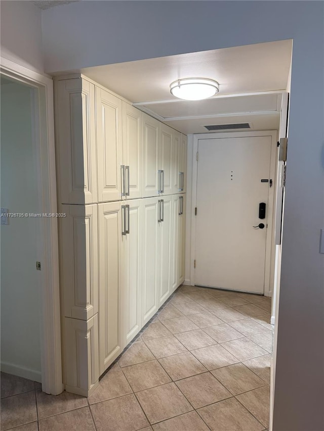 hall featuring light tile patterned floors