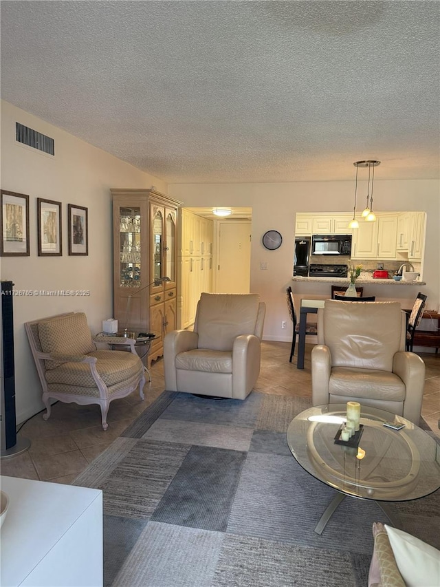 living room with a textured ceiling and tile patterned flooring