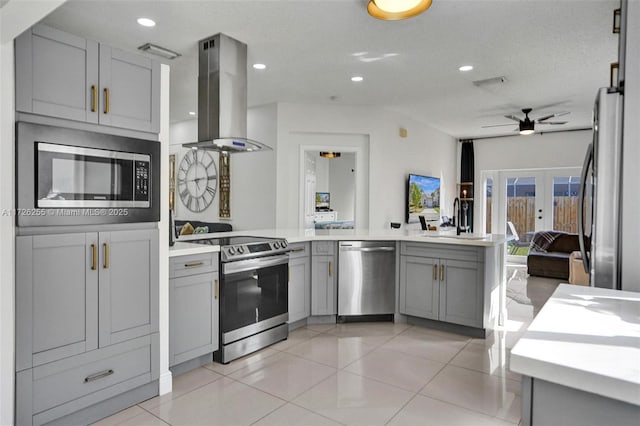 kitchen featuring gray cabinets, kitchen peninsula, island exhaust hood, stainless steel appliances, and french doors