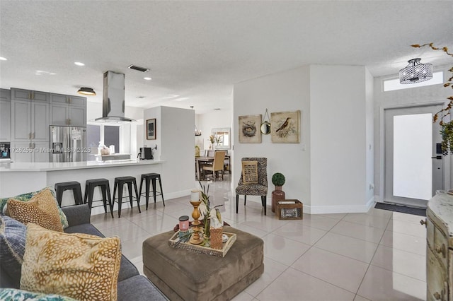 living room with a textured ceiling and light tile patterned floors