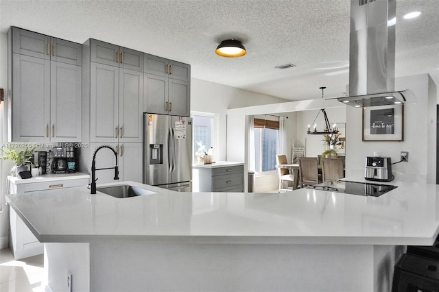 kitchen with black electric stovetop, island exhaust hood, sink, gray cabinets, and stainless steel fridge with ice dispenser