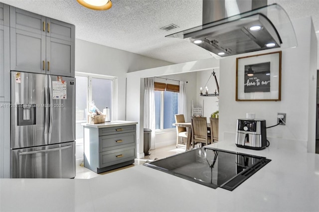 kitchen with a notable chandelier, stainless steel refrigerator with ice dispenser, gray cabinetry, a textured ceiling, and black electric cooktop