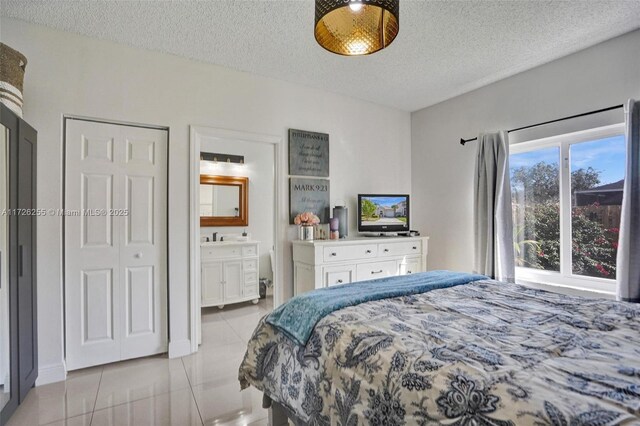 tiled bedroom with a textured ceiling and ensuite bathroom