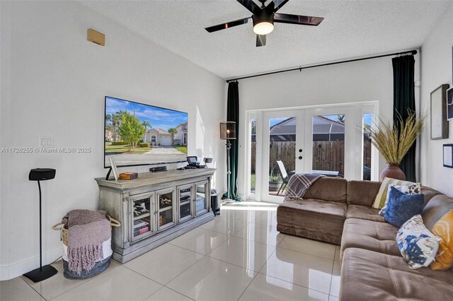 living room featuring ceiling fan, a textured ceiling, light tile patterned floors, and french doors