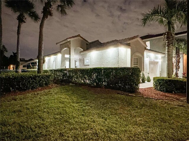 mediterranean / spanish-style home featuring a front lawn and a garage