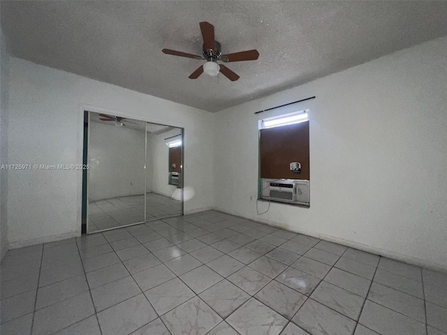 unfurnished bedroom featuring a textured ceiling, ceiling fan, a closet, and cooling unit